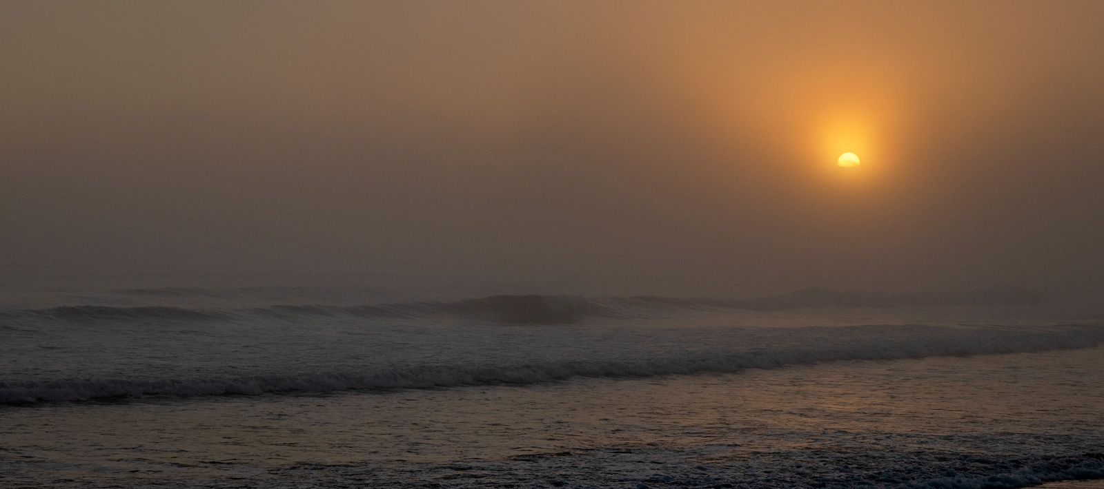 a moody photo of the surf and ocean.