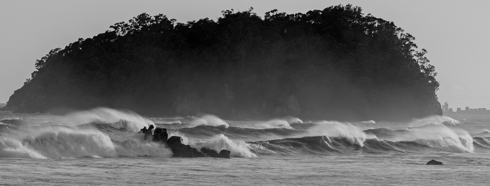 Photograph of a small island beyond the surf.