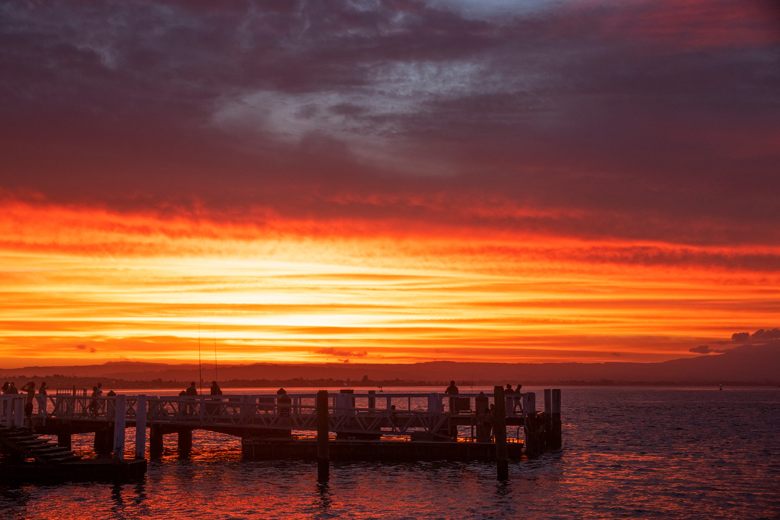 A striking photo of a red sunset with a pier in the foreground